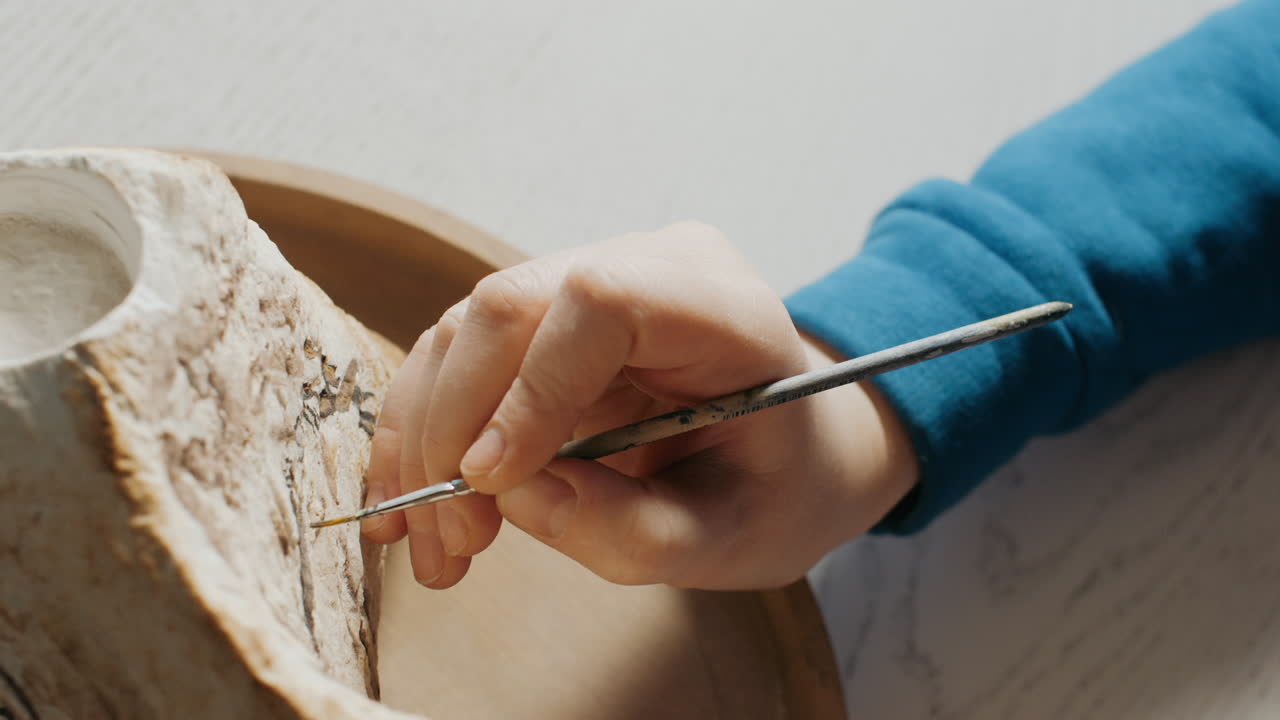 Artist painting a stone sculpture