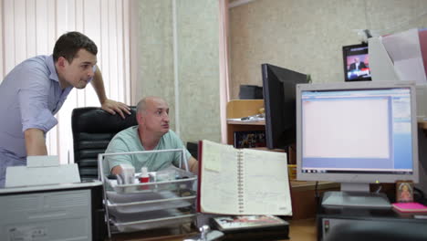 dos hombres están trabajando en la oficina.
