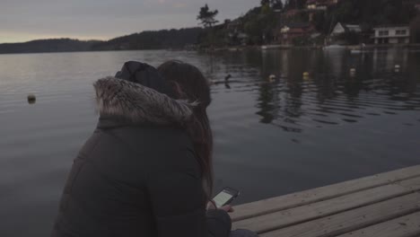 mujer sentada junto al lago