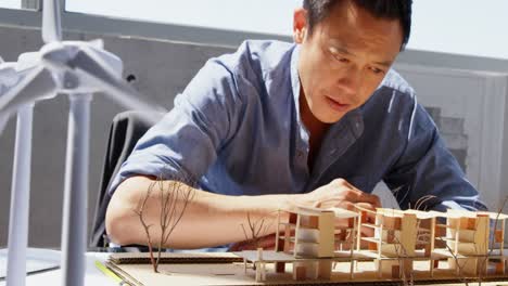 Vorderansicht-Eines-Asiatischen-Männlichen-Architekten,-Der-Das-Architekturmodell-In-Einem-Modernen-Büro-4k-Betrachtet