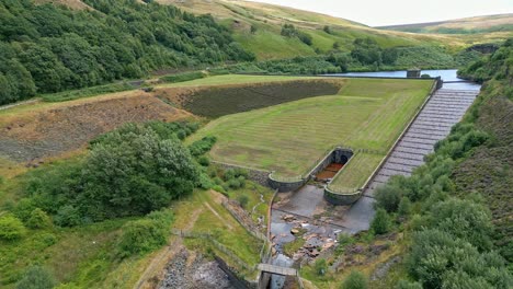 aerial video footage of a reservoir dam wall showing overflow structures