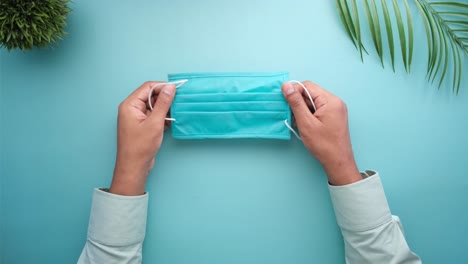 person holding a light blue face mask