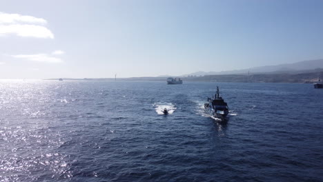 aerial shot towards the prow of the police patrol next to one of the boats it owns