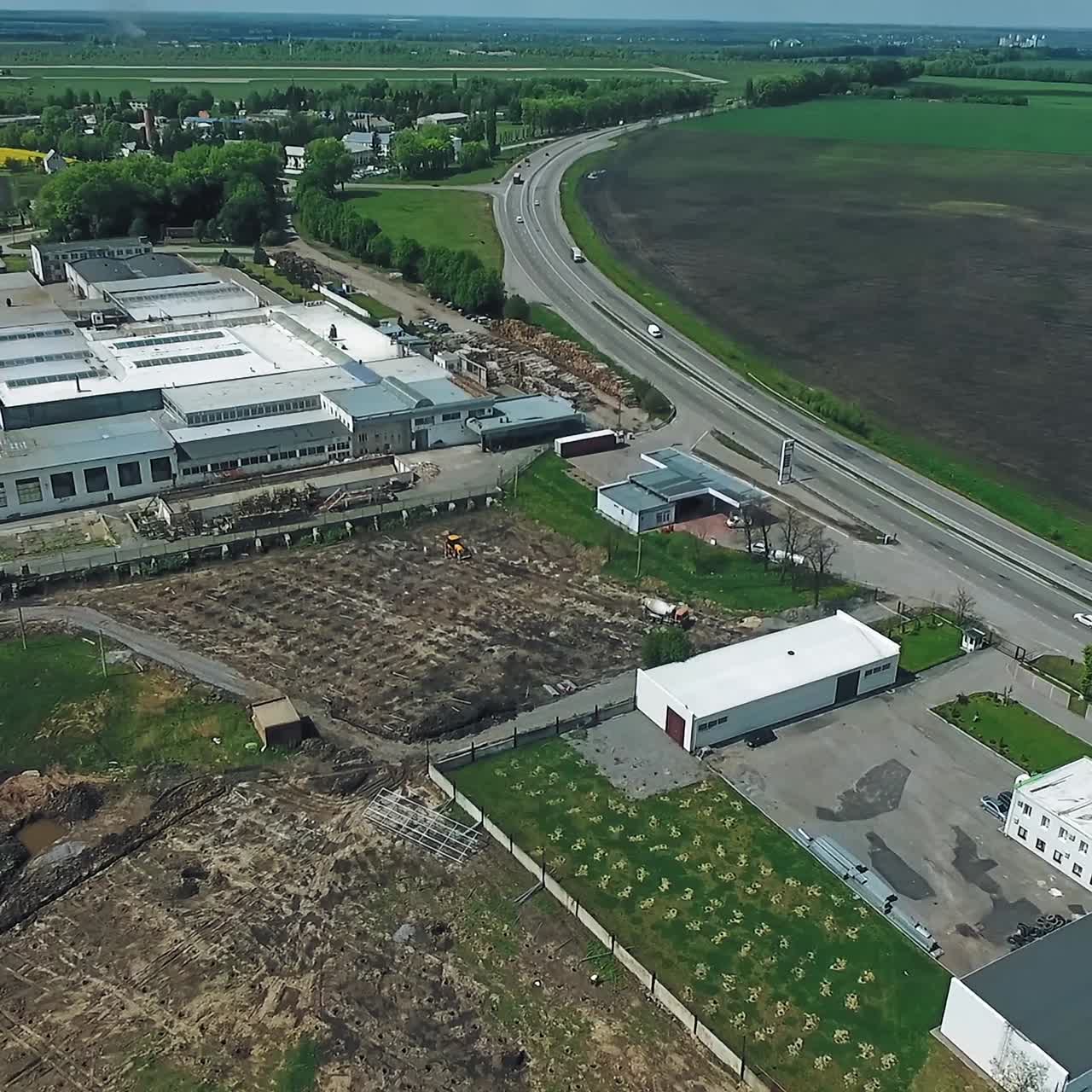 Suburban industrial territory out of big city. Empty construction site for future solar power station. Green fields at backdrop