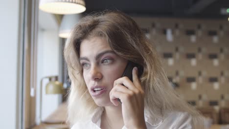 friendly positive young woman talking on mobile phone