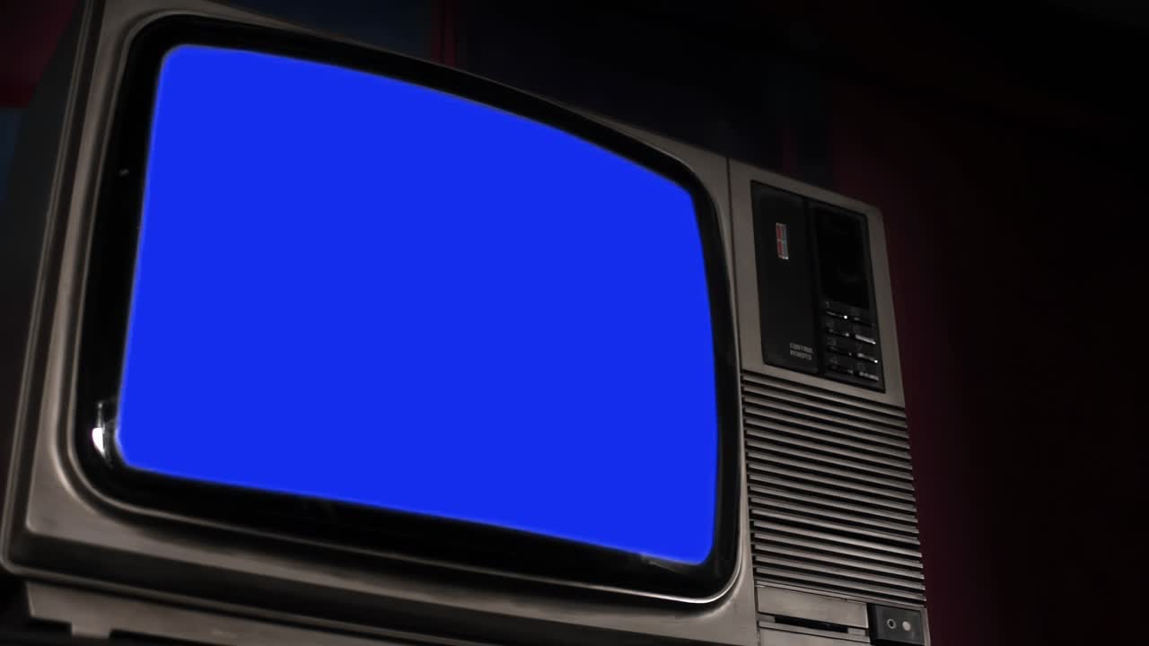 파란색 크로마 키 스크린과 검은색 배경으로 잘라진 오래된 텔레비전. 가까이 가. 확대. 4k 해상도.