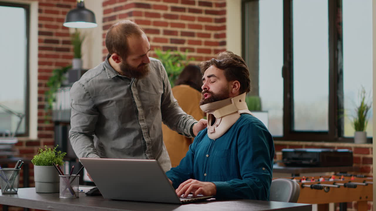 Hurt businessman wearing cervical neck brace at office job