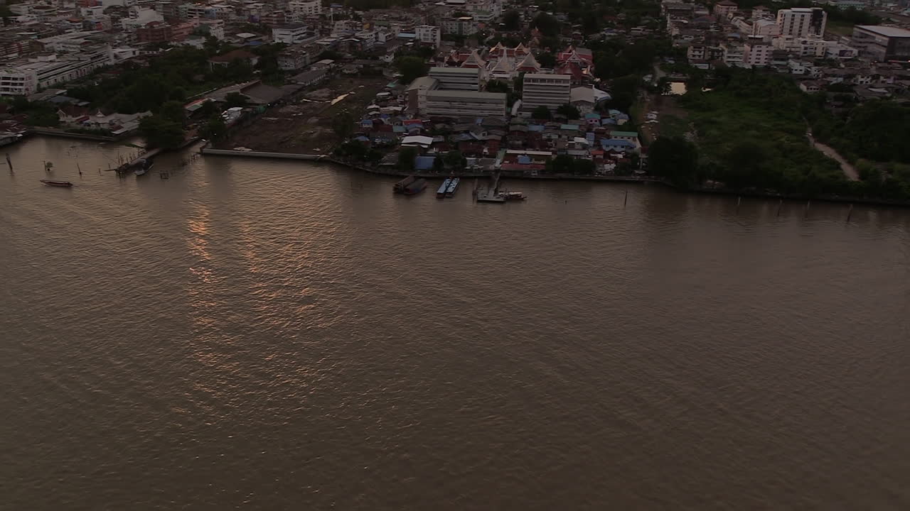 puesta de sol sobre el río chao phraya y el horizonte de la ciudad de bangkok inclinado hacia arriba a la izquierda