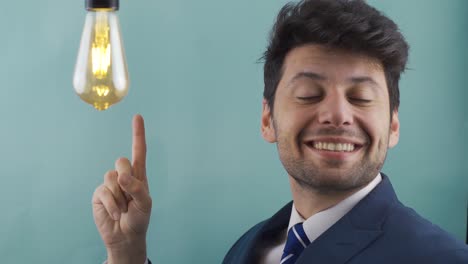 thoughtful businessman has an idea , a symbolic idea lamp lights up above his head.