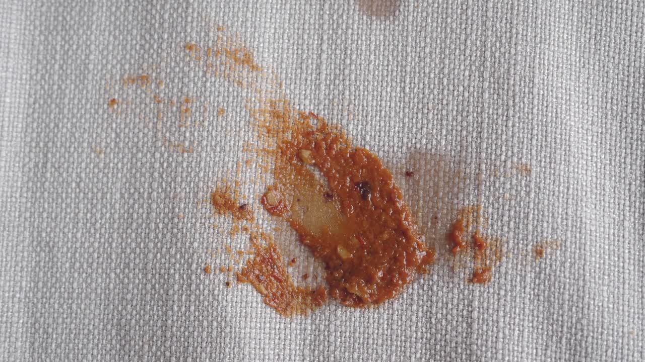 una mancha de salsa roja en un paño blanco