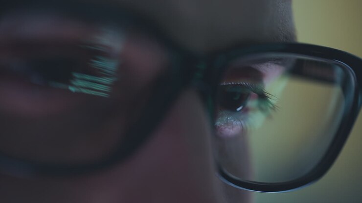 Closeup of person wearing glasses looking at computer screen