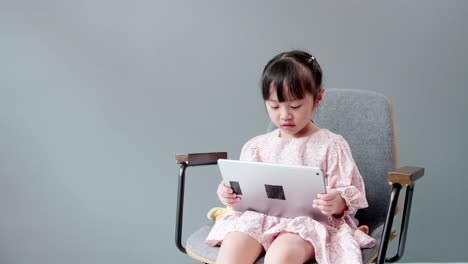 아이가 디지털 태블릿을 보고 명랑한 카메라를 보고 있습니다.