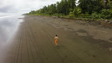 Luftaufnahme-Eines-Mannes,-Der-An-Einem-Leeren-Strand-In-Kolumbien-Joggt-1