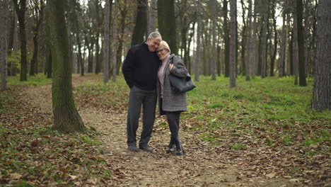 elderly couple enjoying a walk in the park during autumn