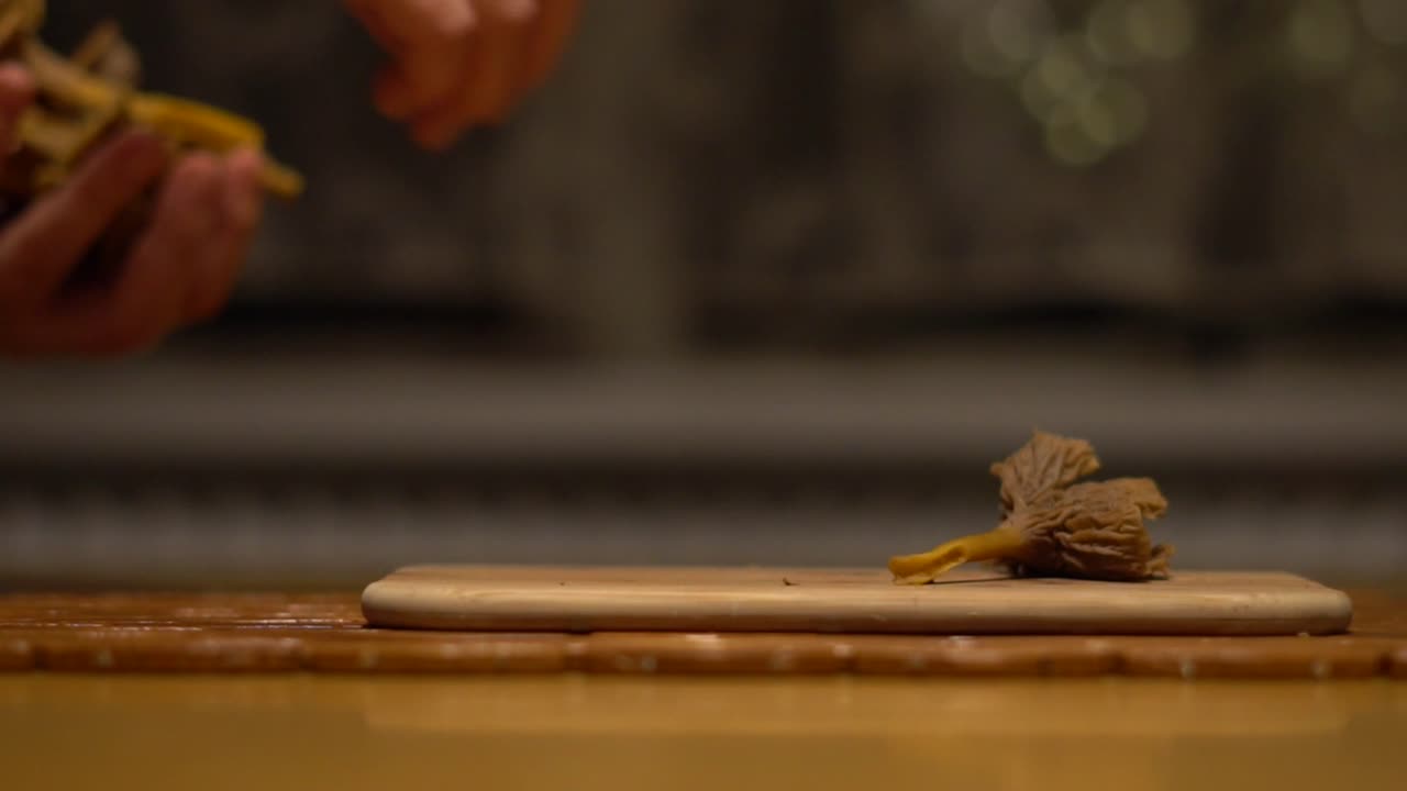 깔때기 살구 버섯을 슬로우 모션으로 하나씩 도마 위에 올려놓는 백인 여성