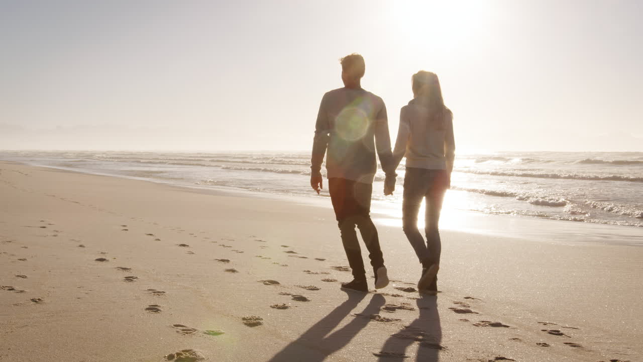 사랑 하는 부부 가 함께 겨울 해변 을 따라  ⁇ 고 있는 뒤 의 모습