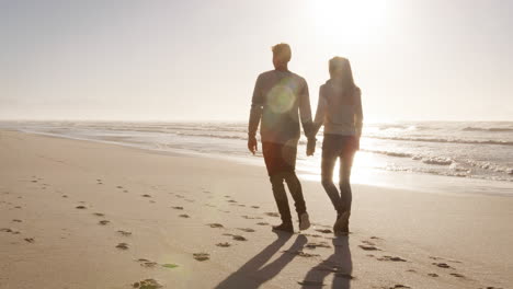 Rückansicht-Eines-Liebenden-Paares,-Das-Gemeinsam-Am-Winterstrand-Entlang-Spaziert