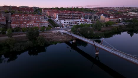 zoom-out aerial video of a bridge in salamanca, spain at twilight