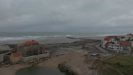 Fort-d'Ambleuse-at-low-tide-with-the-small-coastal-village-Ambleteuse-next-to-it-during-an-overcast-day