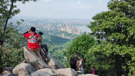 人们爬到山顶的岩石上休息并观看风景