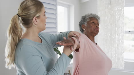 Fisioterapeuta-Femenina-Caucásica-Con-Mujer-Mayor-Haciendo-Ejercicio,-Espacio-Para-Copiar,-Cámara-Lenta