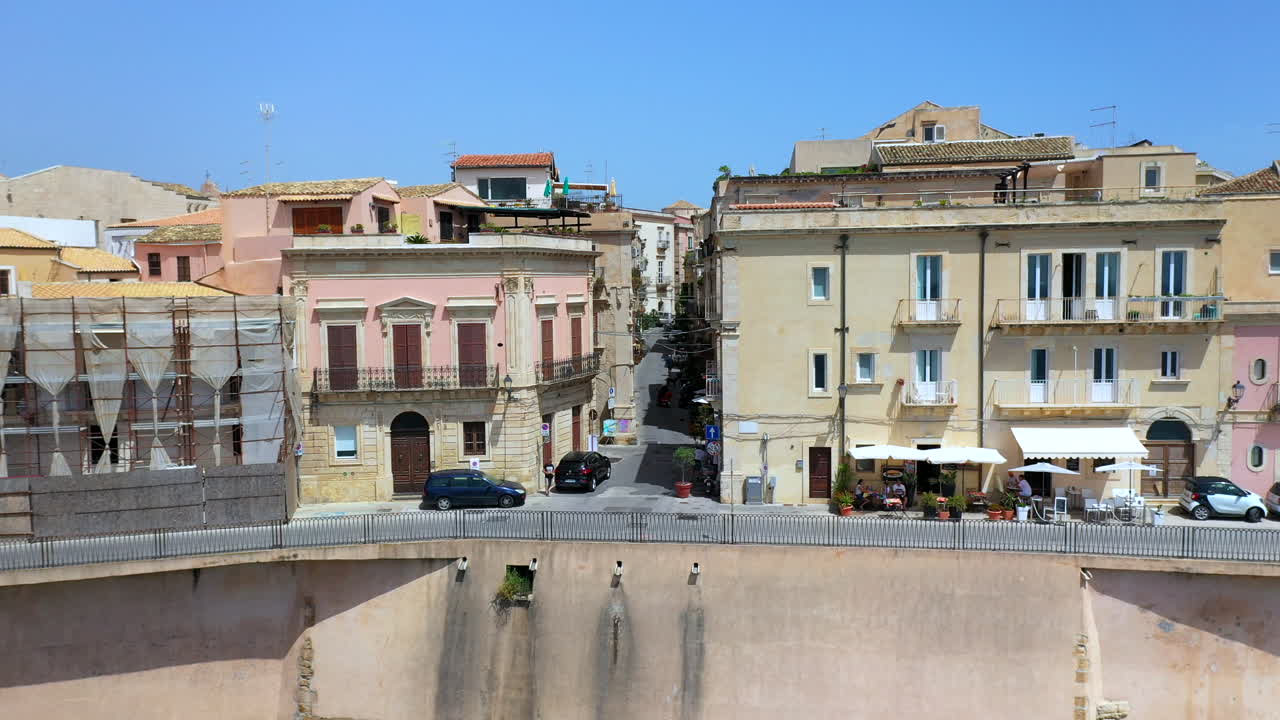 이탈리아 시칠리아 섬의 유서 깊은 도시인 이오니아 바다를 드러내는 시러큐스 건물에서 시작하는 드론 샷