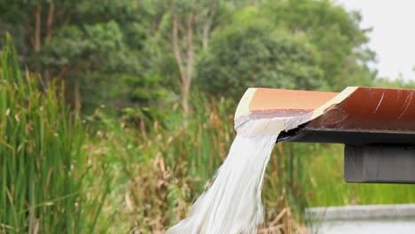 water filling wet land pond from elevated concrete channel drain.