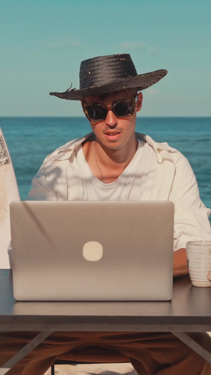 hombre trabajando en una computadora portátil en la playa