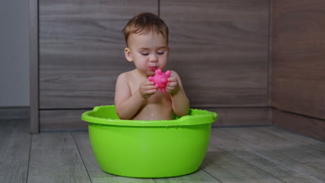 baby playing in a plastic bath