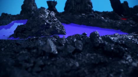 descubra la belleza encantadora de un proyecto de modelo de volcán de planeta líquido, adornado con piedras negras y con hipnotizante agua azul-púrpura en este cautivador metraje