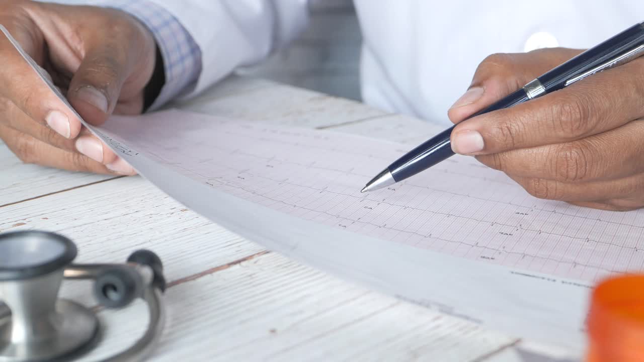 médico que revisa el informe de ecg