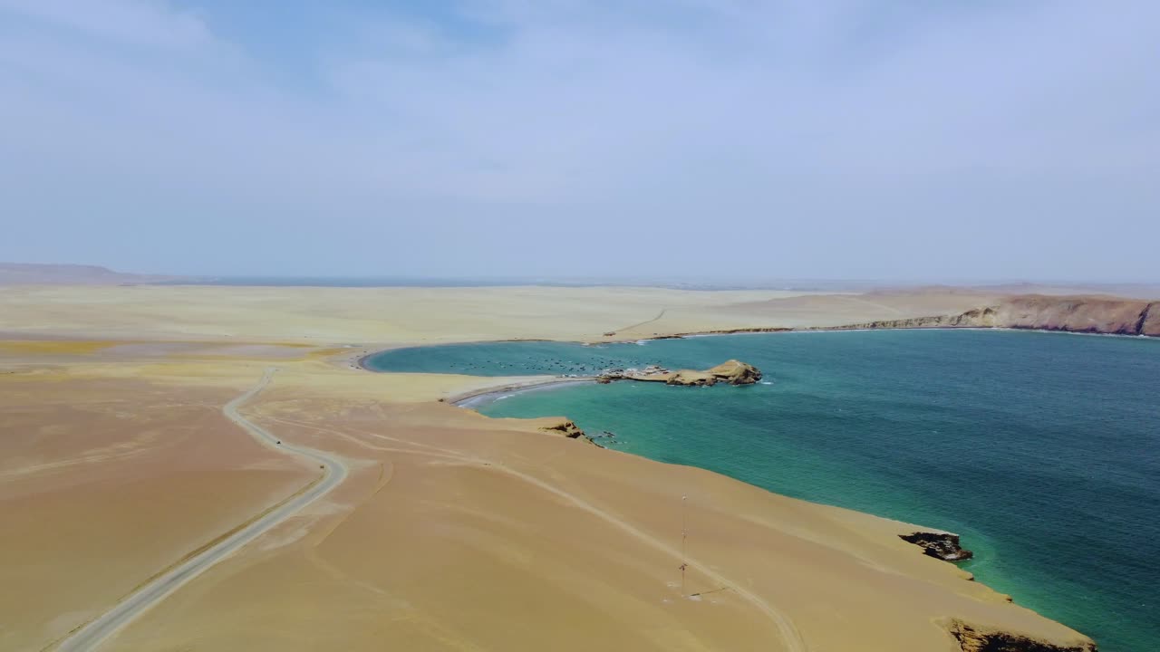 Veduta aerea di costa desertica con strada che conduce a una baia tranquilla