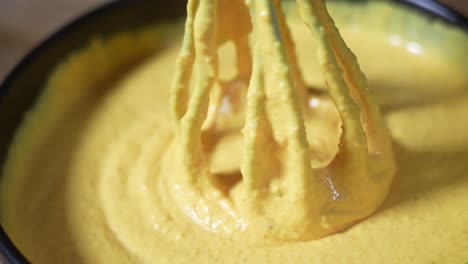 hand mixer close up shoot mixing yellow sauce