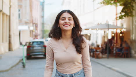 une femme indienne heureuse souriante détournant le regard rêvant reposant de bonnes nouvelles se sent satisfaite dans la rue de la ville