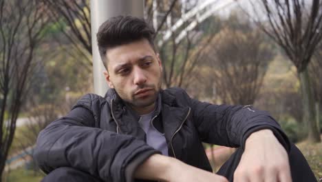 the unhappy man is thoughtful and pensive outdoors.