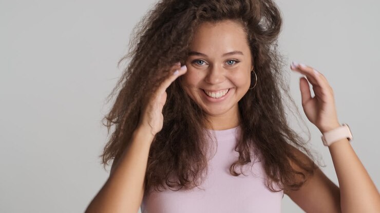 Donna caucasica con capelli ricci in posa per la fotocamera