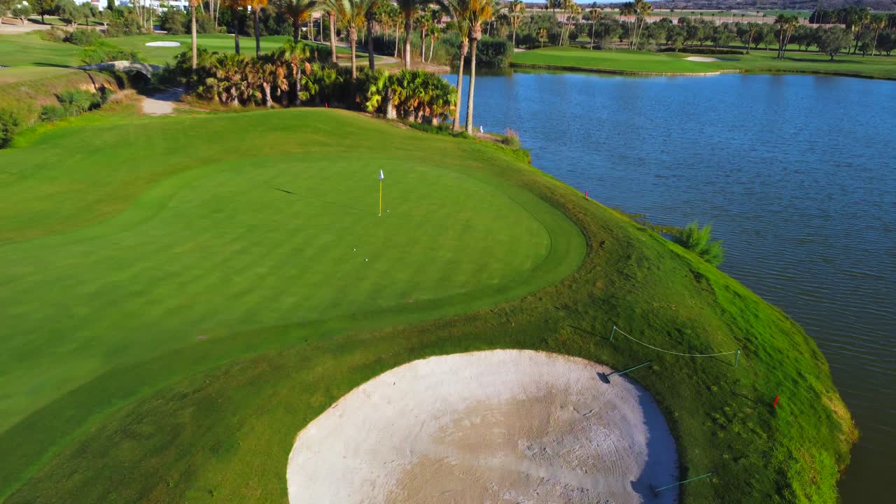 Aerial view of a golf course with a lake and sand trap