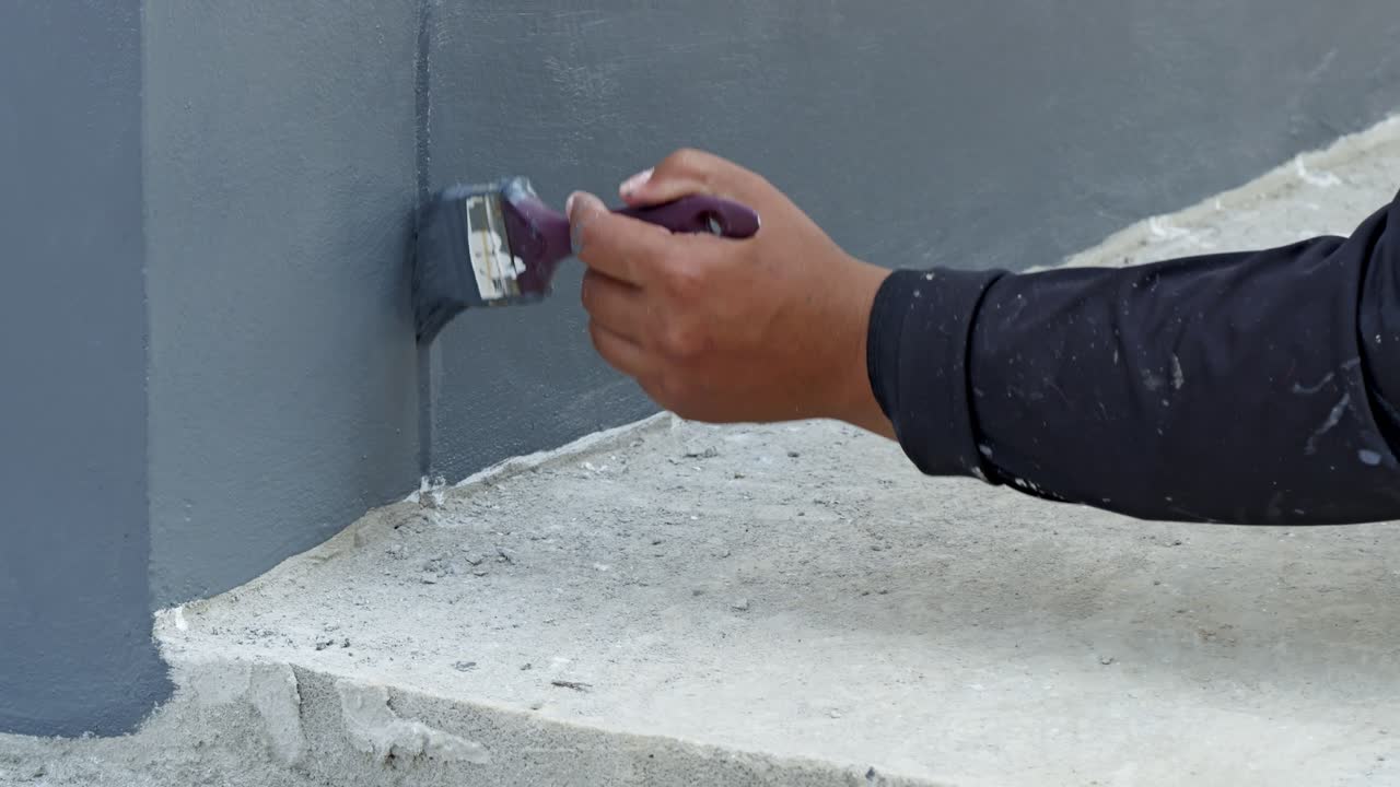 A focused look at meticulous process of painting a wall corner in a DIY home renovation