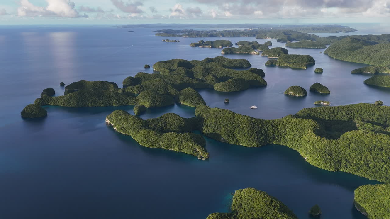 Breathtaking drone view revealing the rich ocean blues and forested island clusters in Palau. Wide revealing drone shot