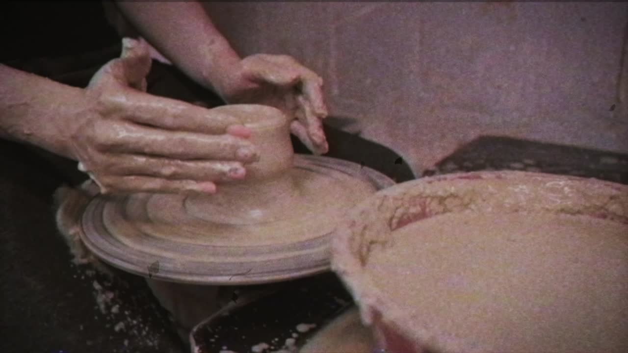 un alfarero enseña a una mujer a hacer platos de arcilla. un hombre toma las manos de una mujer. efecto vintage.
