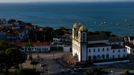 Aerial-view-of-Nosso-Senhor-do-Bonfim-church,-the-city-around-and-the-ocean-at-background,-Salvador,-Bahia,-Brazil