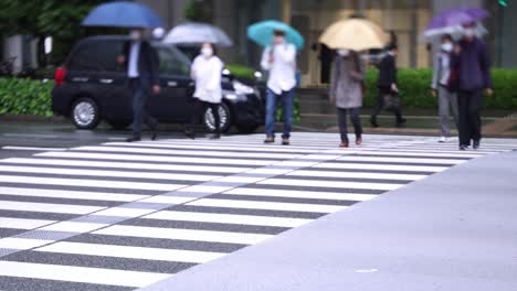 walking people on the street in marunouchi tokyo rainy day