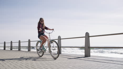 Una-Mujer-Joven-Andando-En-Bicicleta-Por-El-Paseo-Marítimo
