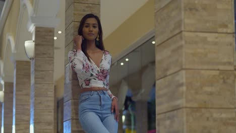 amazing low angle view of a pretty woman playing in her hair while standing in a mall