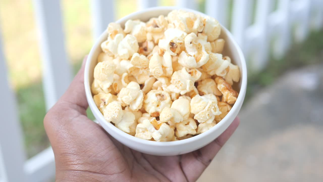 hombres sosteniendo un plato de palomitas de maíz