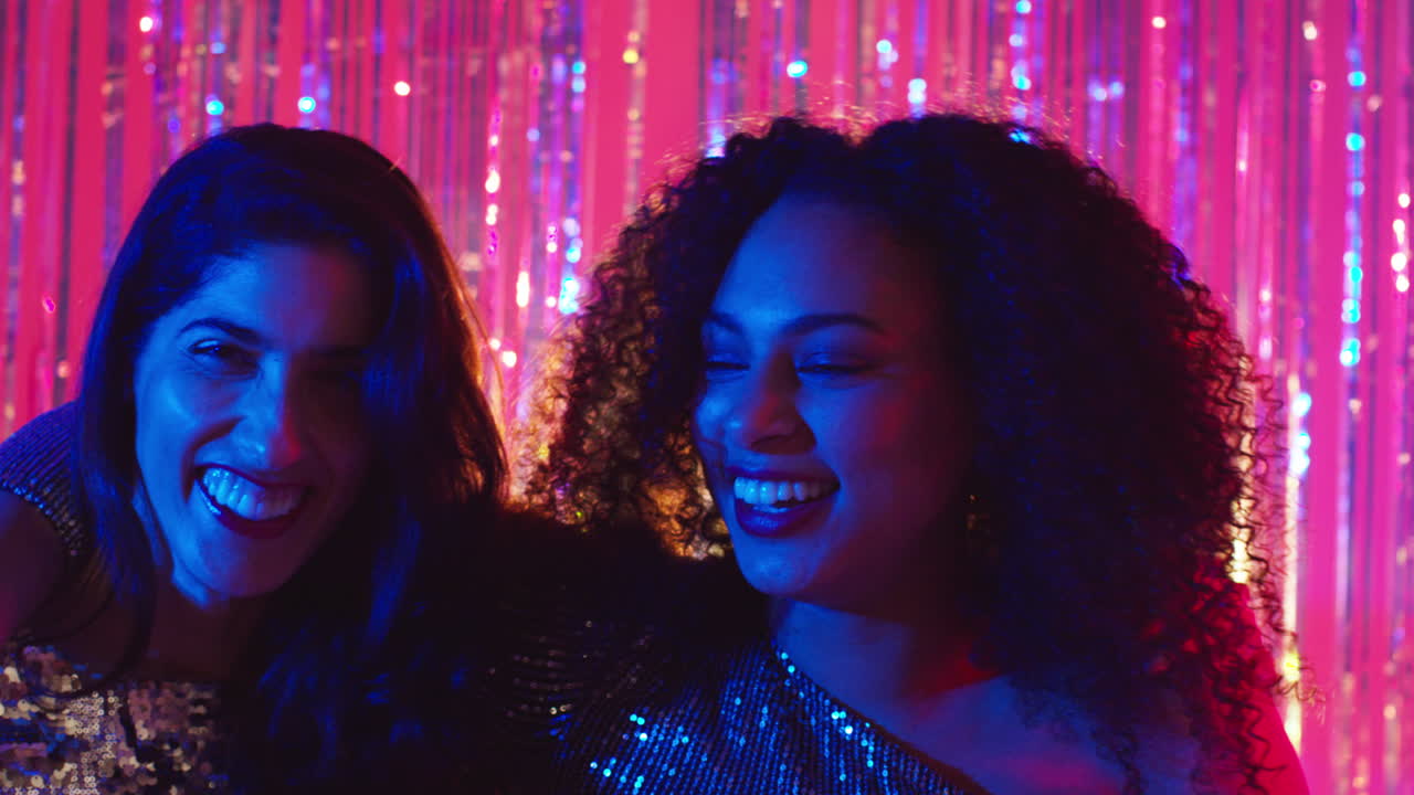Portrait Of Two Women Friends Having Fun Dancing In Nightclub Bar Or Disco With Sparkling Lights