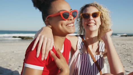 Two-young-adult-female-friends-having-fun-at-the-beach-4k