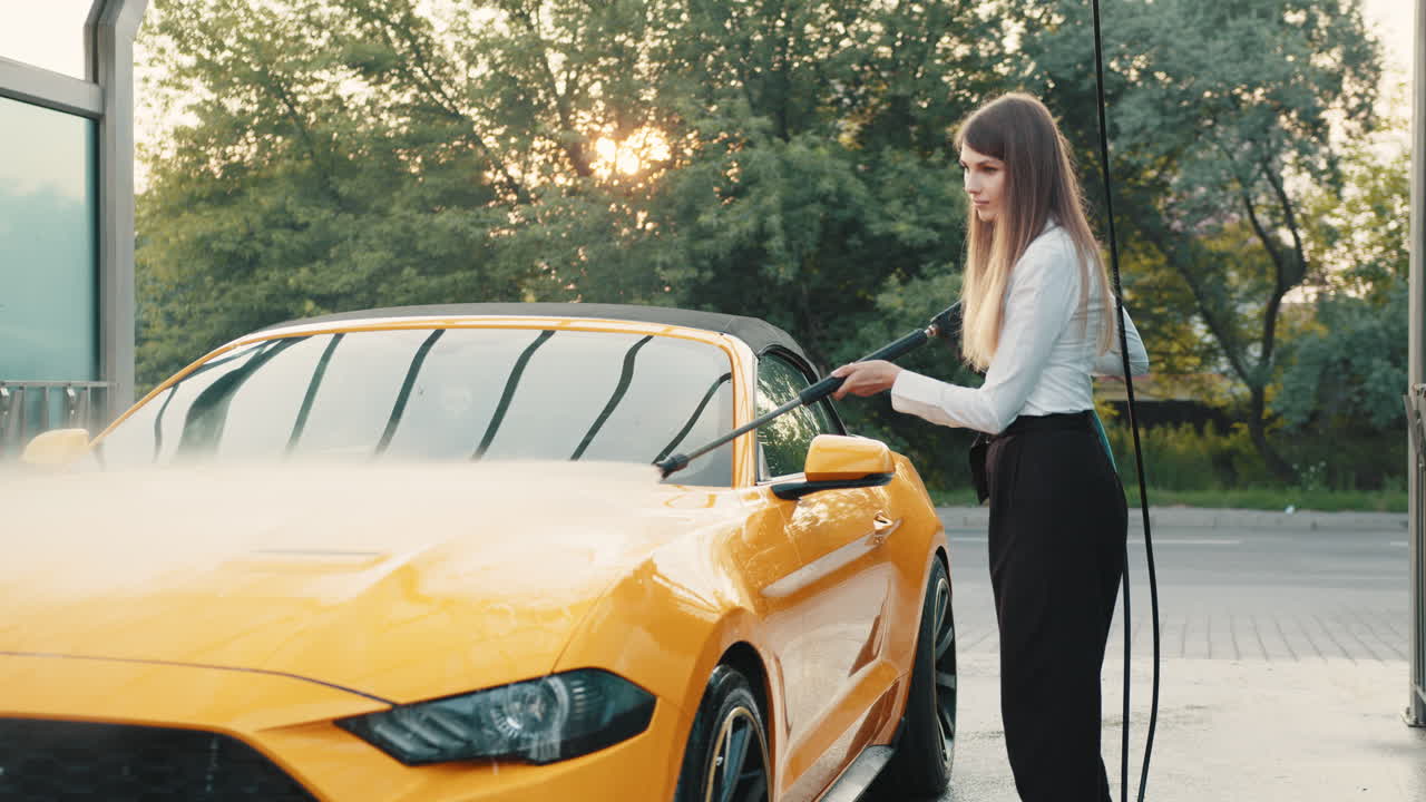 mujer lavando un coche convertible amarillo en un lavado de coches