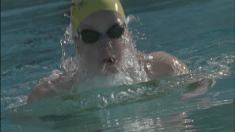 a woman swims across an indoor pool