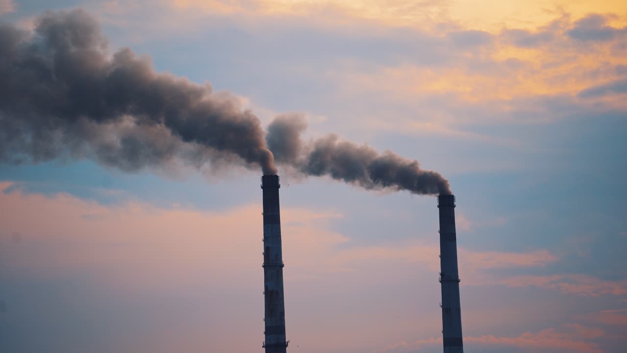 Air pollution by smoke coming out of two factory chimneys. Smoking pipes against the sky. Ecological disaster, air pollution. Environmental problems badly affecting life.